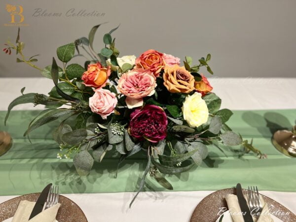 Stunning Floral Arrangement by Blooms Collection: Vibrant magenta, yellow, orange, and pink tones with roses, peonies, eucalyptus, and rose leaves. Ideal for weddings, corporate events, birthdays, and evening functions.