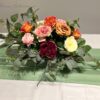 Stunning Floral Arrangement by Blooms Collection: Vibrant magenta, yellow, orange, and pink tones with roses, peonies, eucalyptus, and rose leaves. Ideal for weddings, corporate events, birthdays, and evening functions.